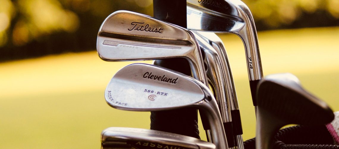 gray steel golf clubs on selective focus photo